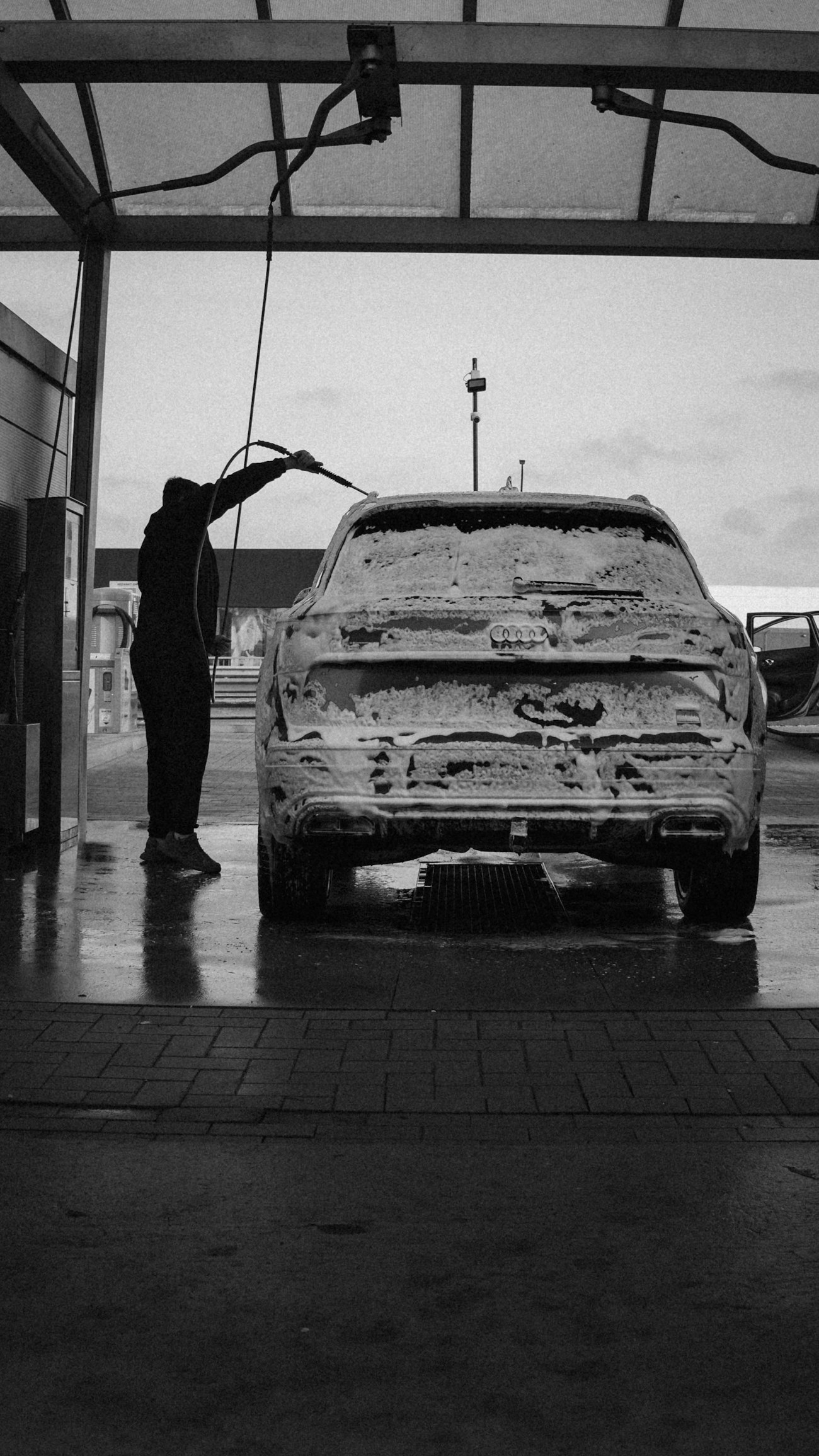 Professional washing a vehicle covered in foam