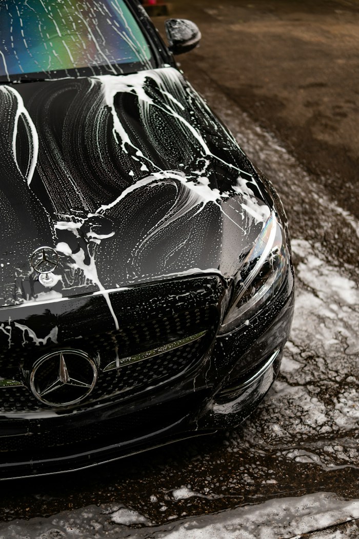 Close view of a black vehicle covered in soap suds
